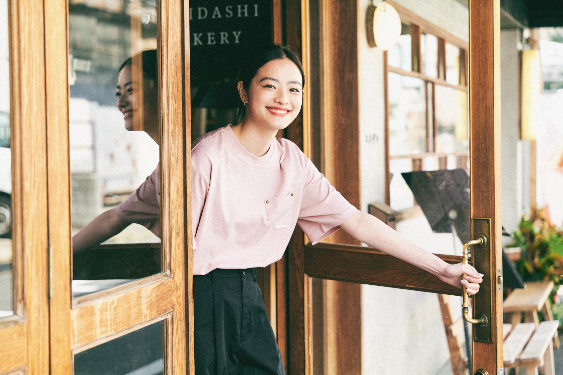 ピンクのBarbourTシャツを着てドアを開ける池田穂乃花